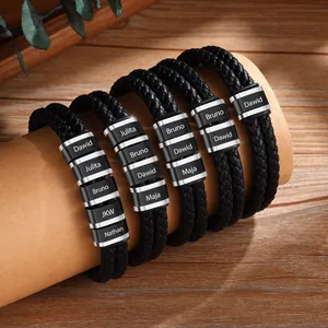 Detail of personalized black braided leather bracelet with engraved steel name beads
