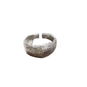 Primo piano di anello artigianale in argento con una texture irregolare effetto martellato