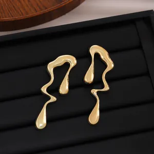 Gros plan détaillé de boucles d'oreilles dorées en métal liquide sur un support noir chic