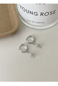 Close-up view of silver lightning bolt hoop earrings with sparkling zircon stones