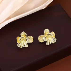 Gros plan sur des boucles d'oreilles fleurs dorées de style vintage en métal irrégulier