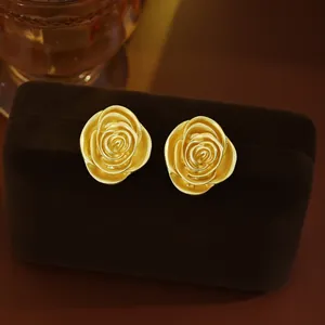 Élégantes boucles d'oreilles roses en métal doré de style vintage sur boîte en velours