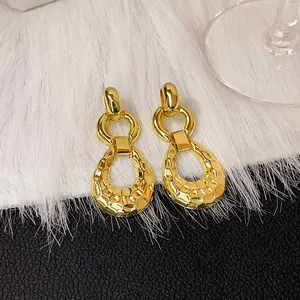 Vue macro très détaillée de boucles d'oreilles rétro en or martelé pour femmes.