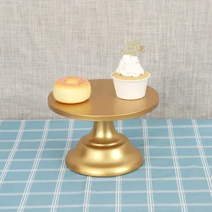 Elegant gold metal dessert display stand holding a cupcake and a donut on a blue tablecloth