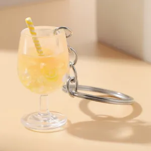 Close-up detail of a miniature lemon juice goblet keychain with a striped straw
