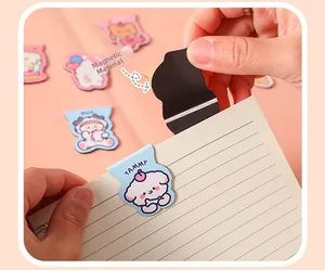 Close-up of cute cartoon magnetic bookmark clips showing internal magnetic backing on paper