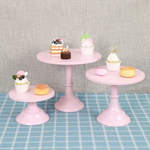 Set of three elegant pink tiered metal cake stands for dessert display and party decoration