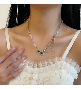 Detail of a Y2K butterfly necklace with colorful gravel and rhinestones worn on a model.