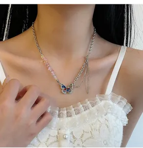 Close-up of a Y2K butterfly necklace with colorful stones and rhinestones on a model.