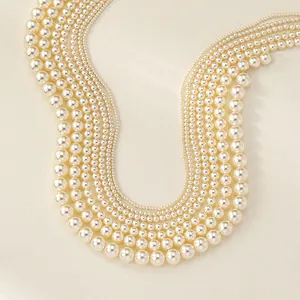 Detailed macro view of multi-layer cream white pearl necklace with varying sizes