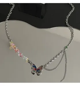 Detailed view of a silver necklace with colorful stones and a rhinestone butterfly