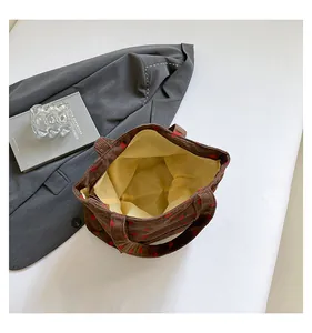 Detailed view of the spacious yellow interior in a strawberry pattern corduroy tote bag