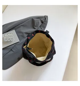 Detailed internal view of black corduroy strawberry tote bag showing lining and pocket