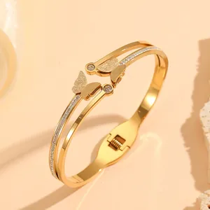 Detailed macro view of gold stainless steel double-layer butterfly bangle with rhinestones