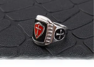 Macro view of retro Crusader cross ring featuring red enamel shield and stainless steel
