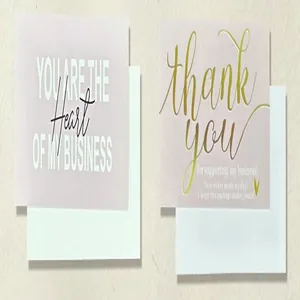 Close-up of minimalist thank you cards with gold foil lettering and envelopes