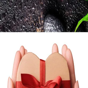 Detailed shot of a brown heart-shaped gift box with red ribbon held in human hands