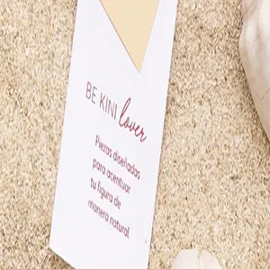 Detailed close-up of a gift thank you card with Spanish text on a sandy beach background.