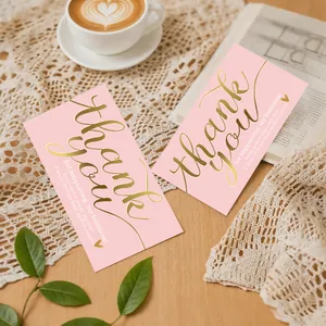 Detailed view of pink business thank you cards with elegant gold foil text on lace