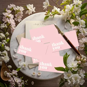A set of pink thank you cards on marble tray surrounded by white cherry blossoms.
