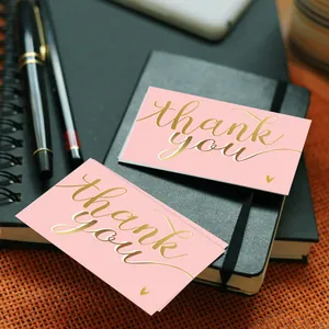 Elegant pink thank you cards with gold foil lettering on a black notebook