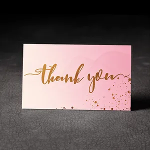 Close-up of pink gradient thank you card with gold foil lettering and dots
