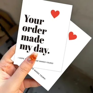 Detailed macro view of minimalist thank you cards featuring a red heart and elegant text