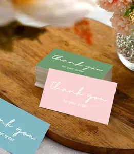 Close-up of elegant pink and green thank you cards for small business order packaging