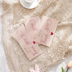 Close-up view of four elegant pink thank you cards displayed on a lace tablecloth.