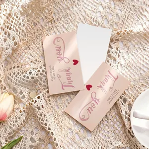 Close-up of elegant pink thank you cards with heart pattern on lace background.