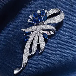 Macro detail of high-end blue crystal brooch with intricate silver pave and leaf design