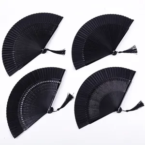 Detail showing four black folding fans with different patterns and elegant tassels.