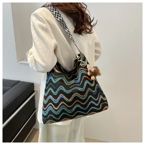 Bohemian style knit shoulder bag featuring colorful chevron patterns and wide geometric strap