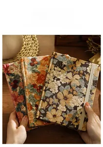 Primer plano de cuadernos A5 vintage de pana con estampado floral y banda elástica