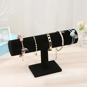 Détail d'un présentoir à bijoux en velours noir en forme de T avec des bracelets