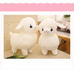 Detailed view of two soft white fluffy sheep plush toys sitting on a beige chair