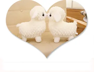 Close-up of two cute white alpaca plush toys facing each other in a heart frame