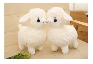 Two soft white plush lamb toys standing on a beige sofa, a perfect birthday gift for kids
