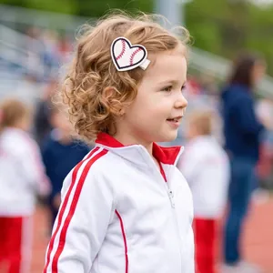 Détail d'une pince à cheveux baseball en forme de cœur portée par une fille sur un terrain.