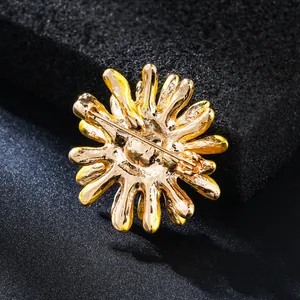 Back view of a gold-tone daisy flower brooch showing the safety pin fastener