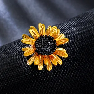 Detailed close-up of a vintage golden enamel daisy brooch with a black stamen center