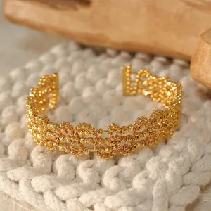 Macro detail showing the intricate gold-plated geometric mesh on this open cuff bracelet