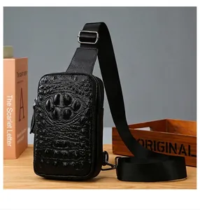 Détail du sac de poitrine en cuir noir pour hommes avec motif crocodile et bandoulière.