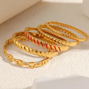 Close-up of gold titanium steel bracelets featuring pig nose and enamel details.