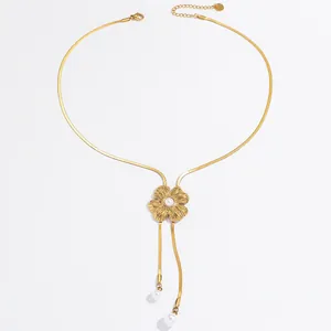 Close-up of gold flower tassel necklace with faux pearl pendant details
