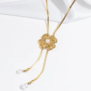 Detail view of a golden flower necklace with elegant pearl tassel pendants.