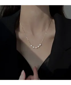 Close-up detail of elegant pearl smile necklace for women on a minimalist chain.
