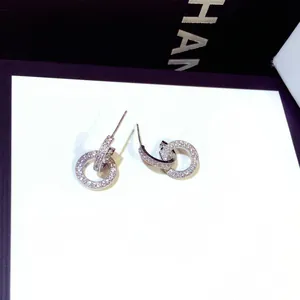 Close-up detail of micro-paved double ring stud earrings featuring S925 silver needles
