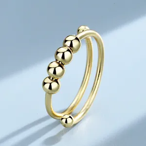 Macro view of a gold-plated fidget ring featuring rotating beads for anxiety relief