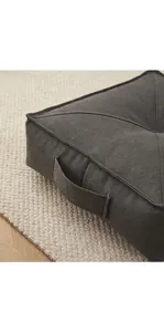 Detail view of thick charcoal gray floor cushion with handle and soft textured fabric texture